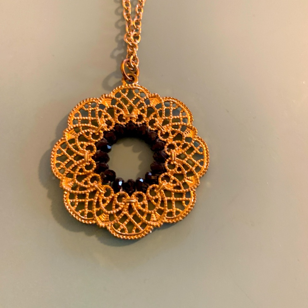 Gold necklace with black and gold circle pendant